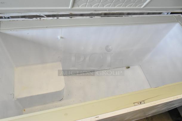 Chest freezer with hinge lid, 115 volts, 1 phase. Interior shows signs of wear. Ideal for home or commercial use.