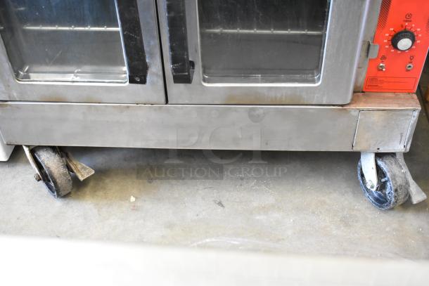 Vulcan VC4GD stainless steel commercial convection oven with view-through doors, metal racks, therm. controls, on casters.