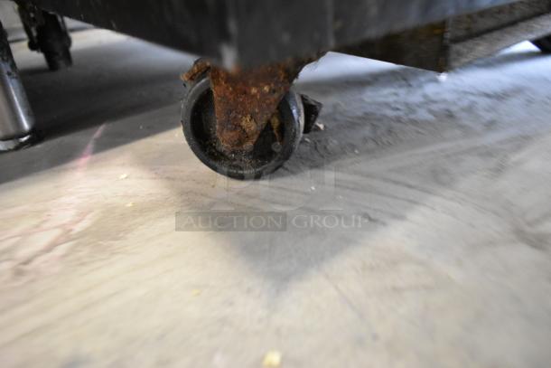 Close-up of a rusted caster on a Micro Matic MDD-23 kegerator. Commercial quality, 115 volts, 1 phase. Condition shows wear.