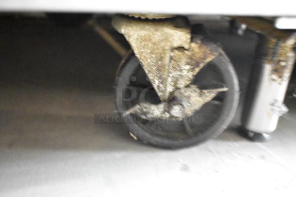 Bison MSF8308 bain marie table caster, shows some rust and wear, indicating usage. Visible part of stainless steel leg.