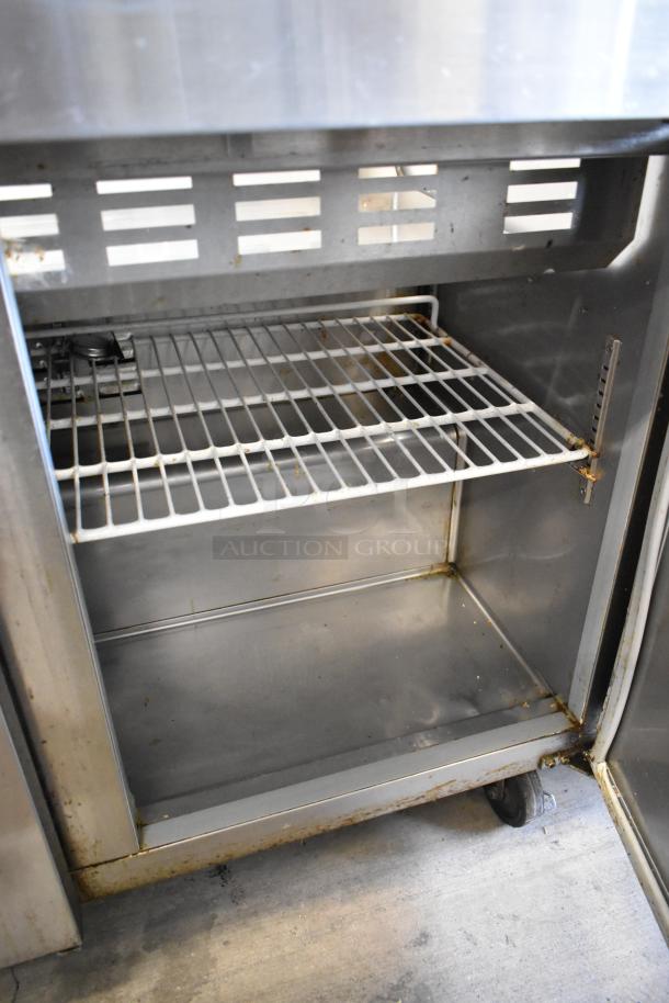 Avantco 178SCLM3 stainless steel commercial sandwich prep table with bain marie top, on casters, visible wear inside.