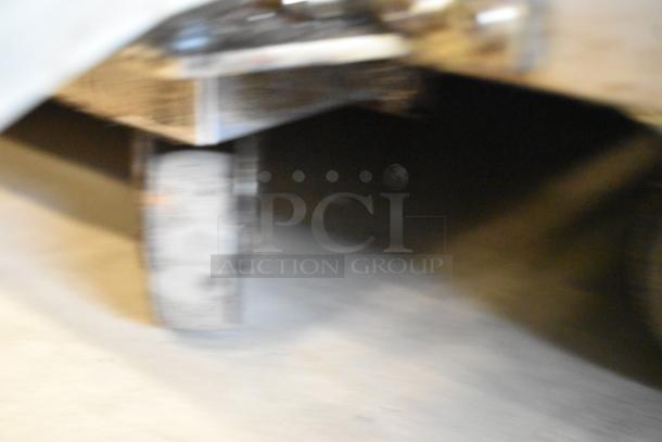 Blurry image of Avantco 178SCLM3 sandwich salad prep table's caster. Stainless steel construction, commercial quality.