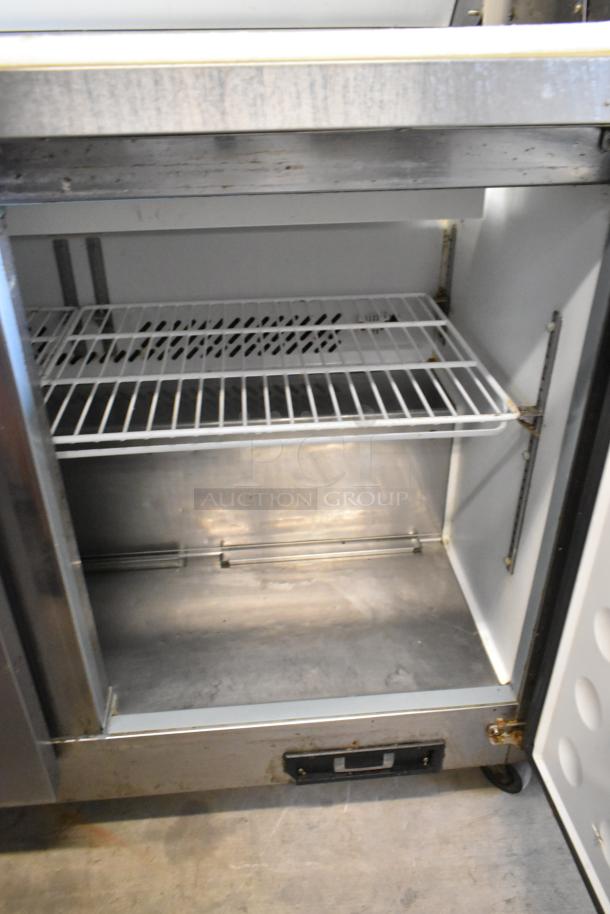 Ikon KSP48 stainless steel prep table with shelves and commercial casters, 115V, shows interior storage and condition.