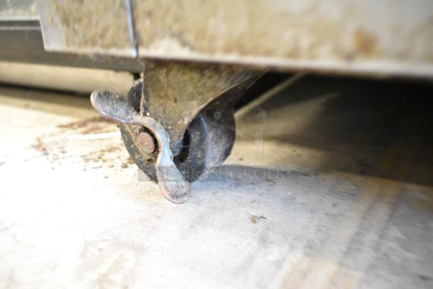 Close-up of a commercial caster on an Ikon KSP48 prep table, showing signs of wear and surface rust.