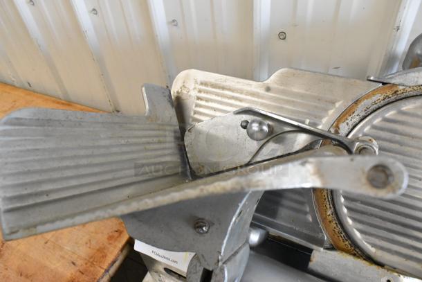 Globe 285 metal commercial meat slicer with blade sharpener, shows signs of wear. 115V, 1 Phase. Auction label visible.