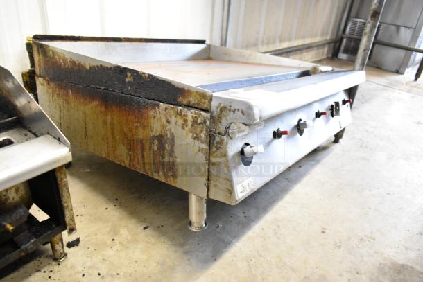 Garland Stainless Steel Gas Flat Top Griddle, commercial countertop model, shown with rust, used condition, control knobs visible.