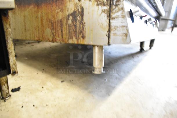 Garland stainless steel commercial countertop gas griddle, showing rust and wear on the exterior, adjustable feet visible.