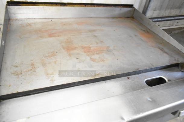 Garland stainless steel commercial gas flat top griddle, used condition, showing surface wear, ideal for heavy-duty cooking.