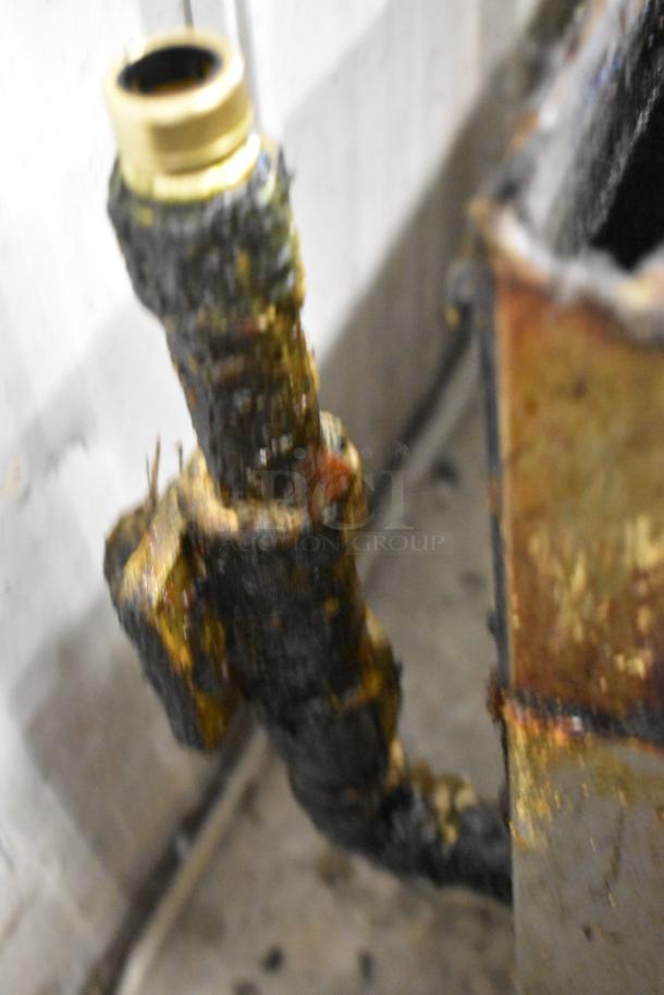 Blurred close-up of a connection detail on a Garland stainless steel commercial countertop gas-powered flat top griddle.