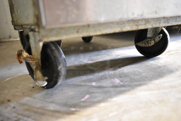 Close-up of a caster wheel from a 2023 Ikon IGF-35/40-NG stainless steel deep fryer, showing signs of wear.