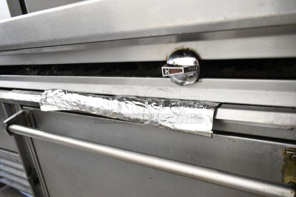 Jade stainless steel commercial gas range with 2 burners, oven, over shelf, backsplash, and commercial casters.