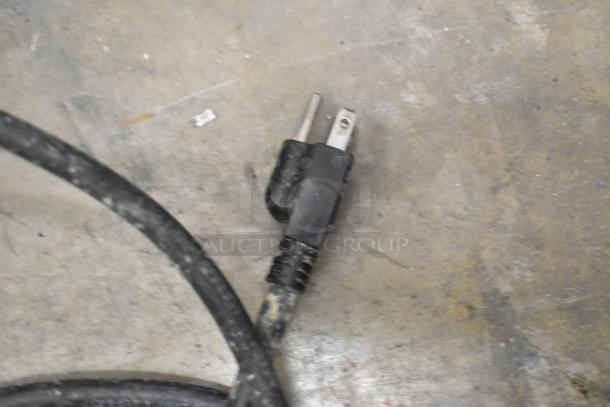 Power plug of Presto PM-20 Planetary Dough Mixer. 115 Volts, 1 Phase. Cord condition shown, resting on a concrete surface.