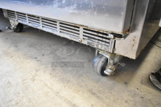 Beverage Air UCF27A-23 stainless steel undercounter freezer, commercial casters, visible wear and tear, model label attached.