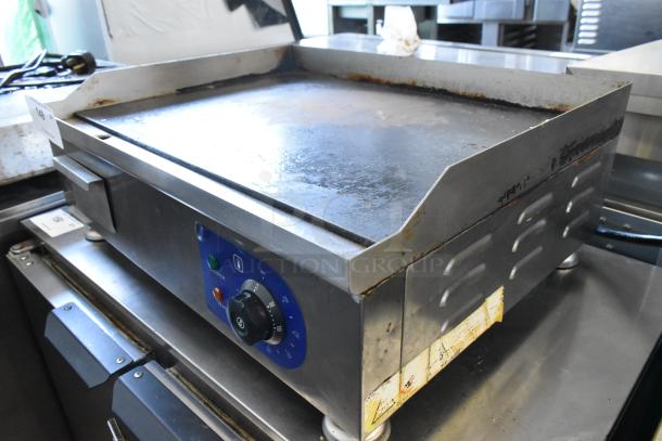 Stainless steel commercial countertop electric griddle, flat top, 110 volts, 1 phase, visible wear, control knob and power indicator.