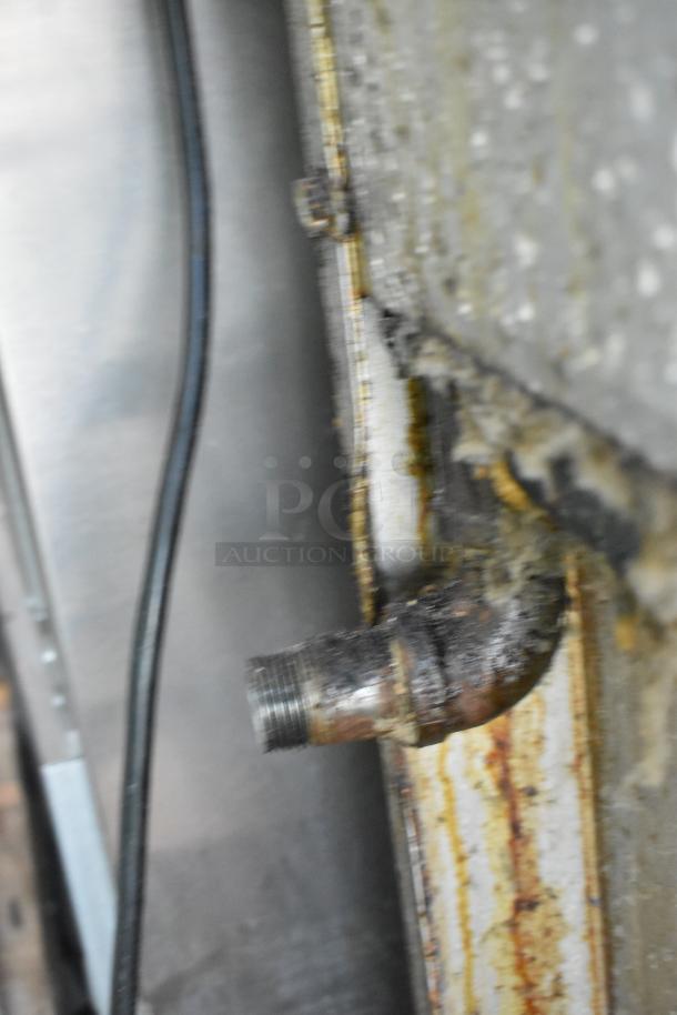 Blurry close-up of the connection area on a Jade Range J9R-6-36 commercial 6 burner gas range, showing signs of wear.