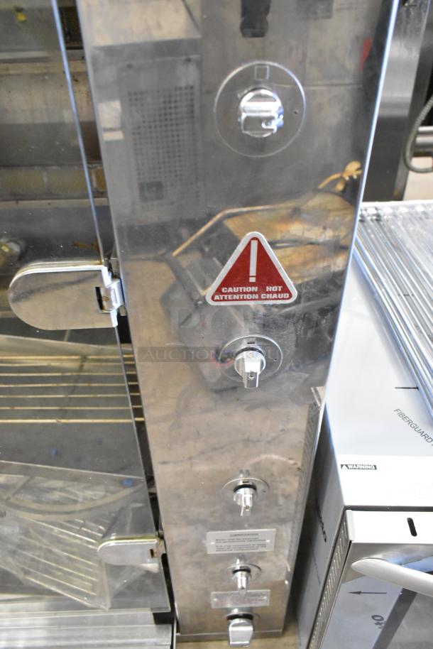 Rotisol 1160.4 metal commercial natural gas rotisserie oven featuring control knobs, caution label, and stainless finish.