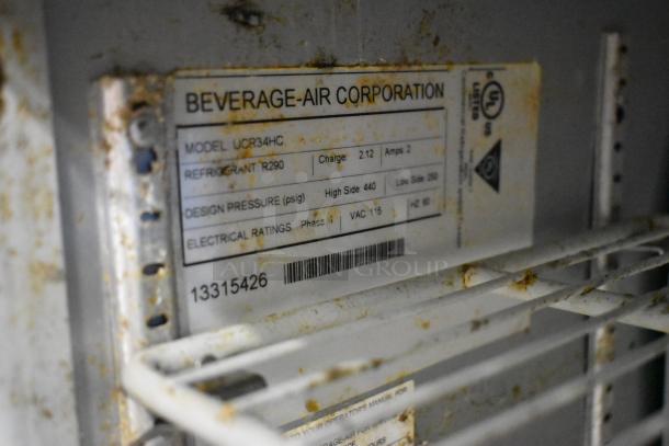Beverage Air UCR34HC cooler label indicating model, refrigerant type, design pressure, and electrical ratings. Slight rust visible.