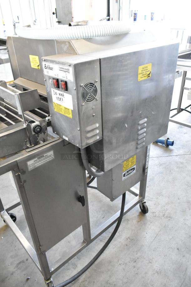 Belshaw TG50 stainless steel thermoglazing station, commercial casters, 208V, 1 phase. Labels indicate warnings and usage instructions.