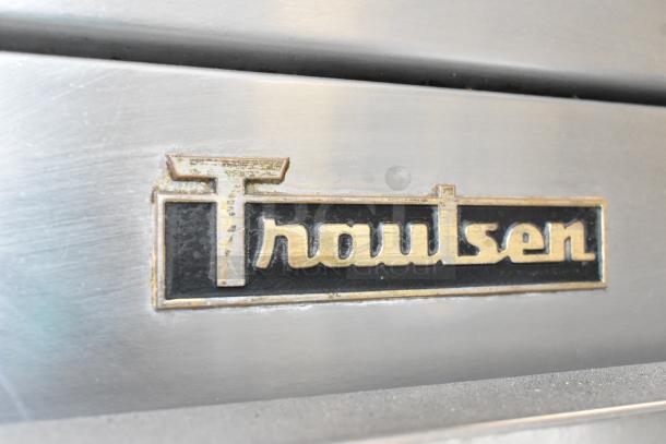 Traulsen G10010 logo on stainless steel commercial cooler, showcasing brand emblem on textured surface.