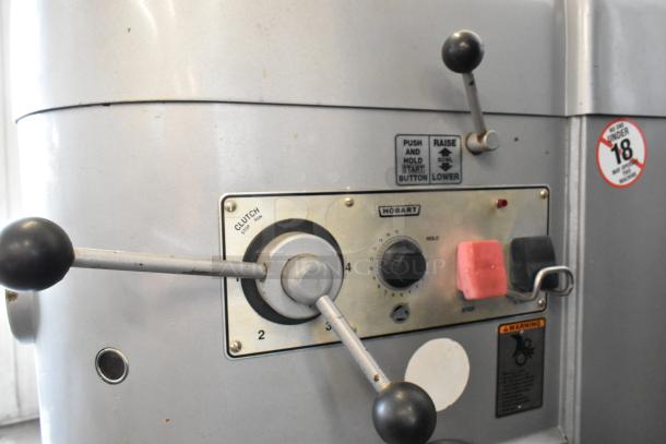 Hobart M802 mixer control panel showing clutch lever, speed dial, and start/stop buttons. Labels indicate operation instructions.