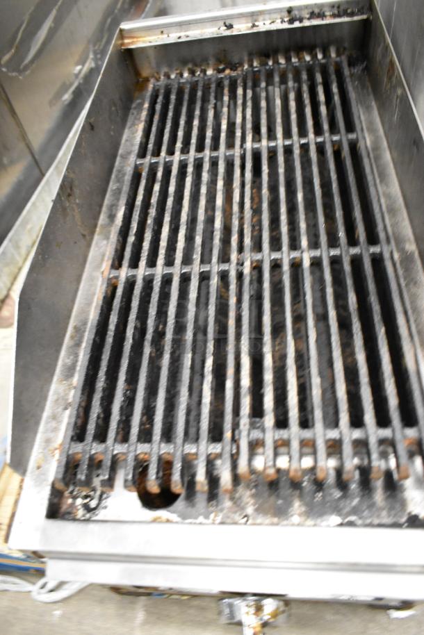 Stainless steel commercial natural gas charbroiler grill, model RLRM-23-12. Shows wear, functional grates visible.