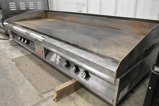 Lang stainless steel commercial countertop flat top griddle in used condition, featuring multiple control knobs.