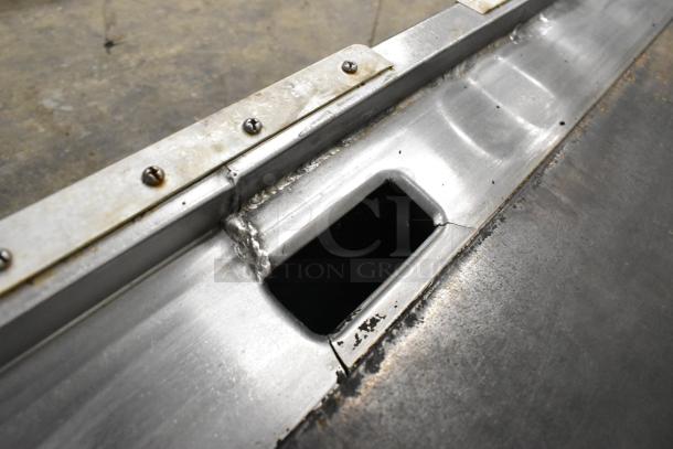 Lang stainless steel commercial countertop flat top griddle, close-up of drainage opening, sturdy welded construction.