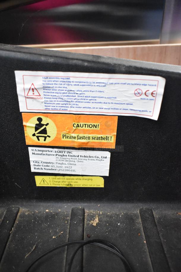 2022 Pinghu 2000W Electric Children's Car warning labels, safety instructions, manufacturer details, and cautionary notices.