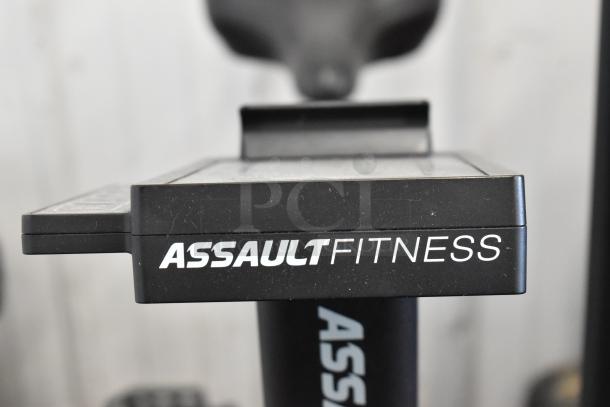 Assault Fitness stationary exercise bicycle with display panel. Features durable construction, brand logo visible.