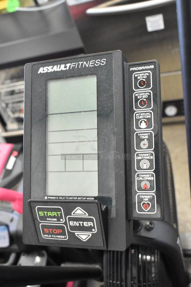 Assault Fitness stationary exercise bicycle display with program options and start/stop buttons, in good condition.