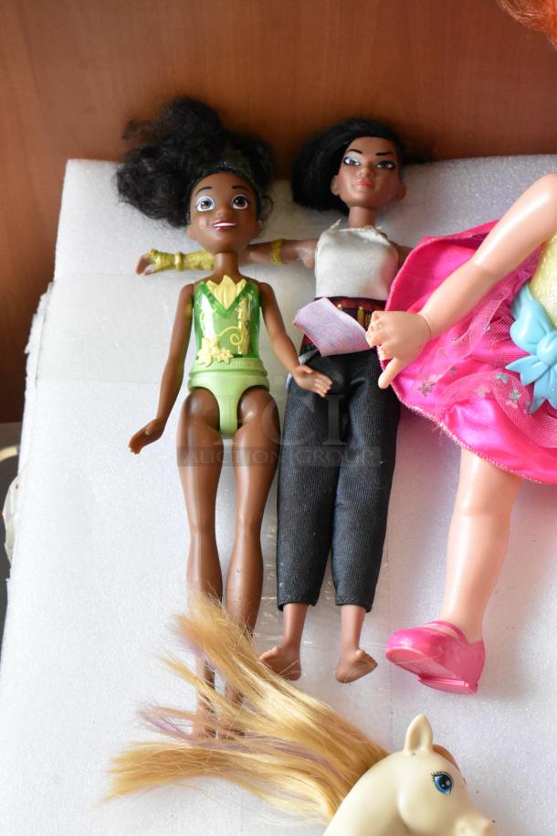 Lot of various dolls including two fashion dolls and parts of a pony. Dolls in casual and colorful attire, fair condition.