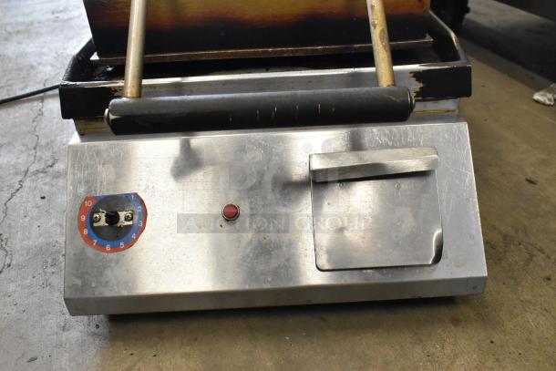 Metal commercial countertop panini press, used condition. Features 115 volts, 1 phase, temperature dial, and power indicator.