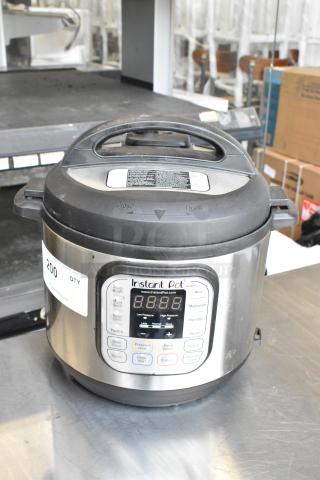 Instant Pot IP-DUO60 Metal Commercial Countertop Pressure Cooker, 120 Volts, black lid, control panel visible, good condition.