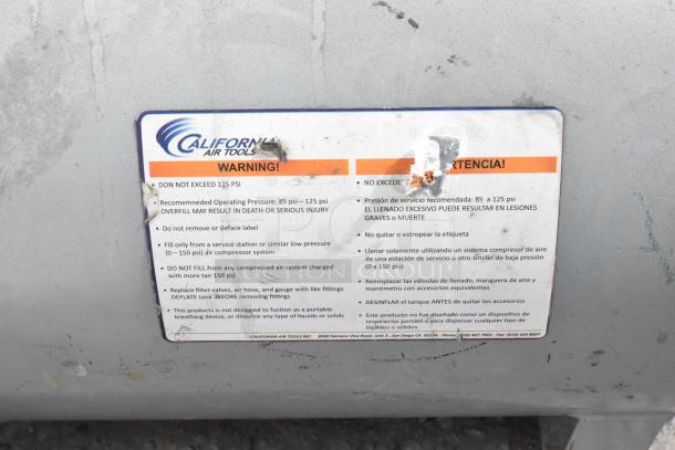California Air Tools tank with warning label. Max 125 PSI, recommended 85-125 PSI. Instructions for safe use are visible.