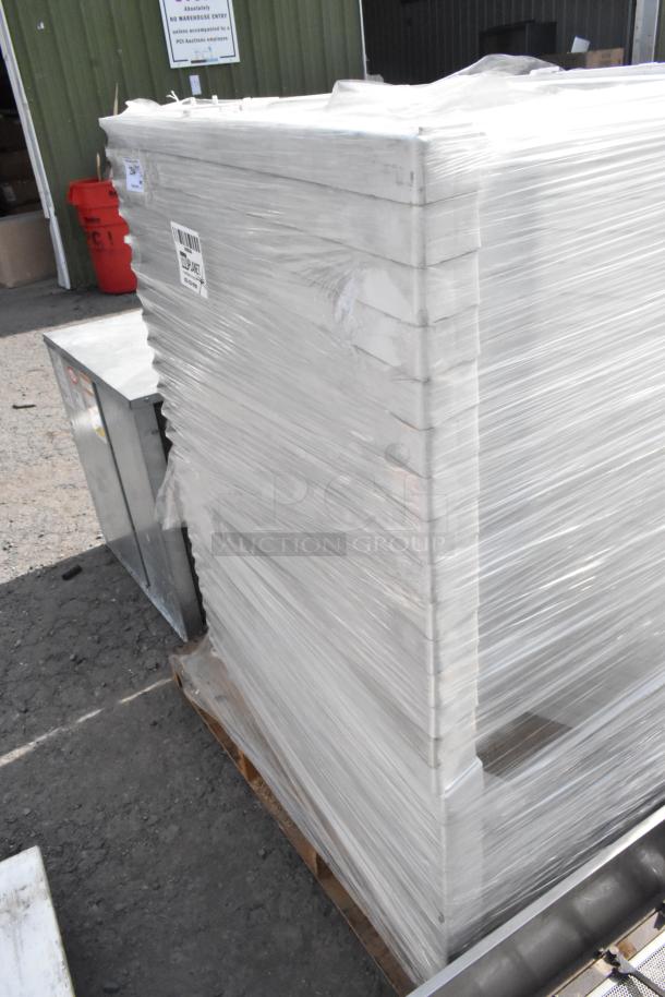 25 white units stacked on a pallet, wrapped in clear plastic, in good condition. Auction lot includes 25 sets.