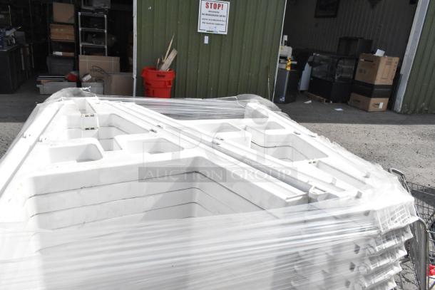 Stack of 25 white units wrapped in plastic, ready for auction. Units appear in good condition, ideal for bulk purchase.