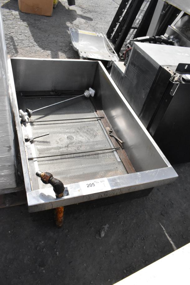 Stainless steel commercial grease trap, visible mesh filter, minor rust on outlet, condition used, tag reads "205."