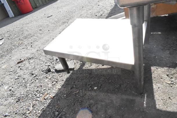 Stainless steel 3 bay sink with dual drain boards, shown on outdoor surface. Solid construction and durable design.