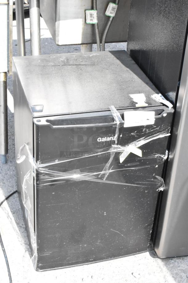 Galanz GLR25MBKE02 mini cooler, black, visible wear, taped shut, 115 volts, auctioned with three other coolers.