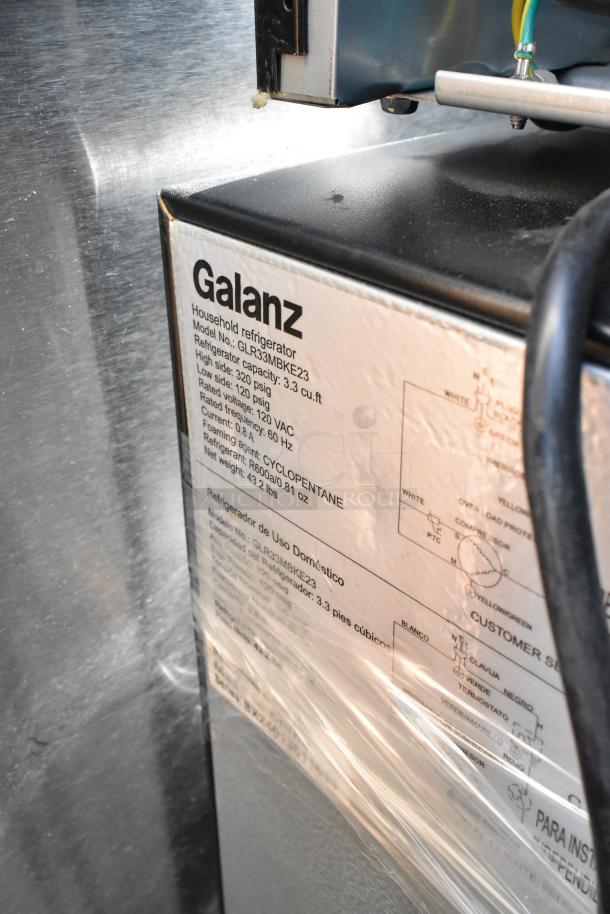 Galanz GLR33MBKE23 mini cooler label showing model, capacity 3.3 cu.ft, voltage 120 VAC, and net weight 43.2 lbs.