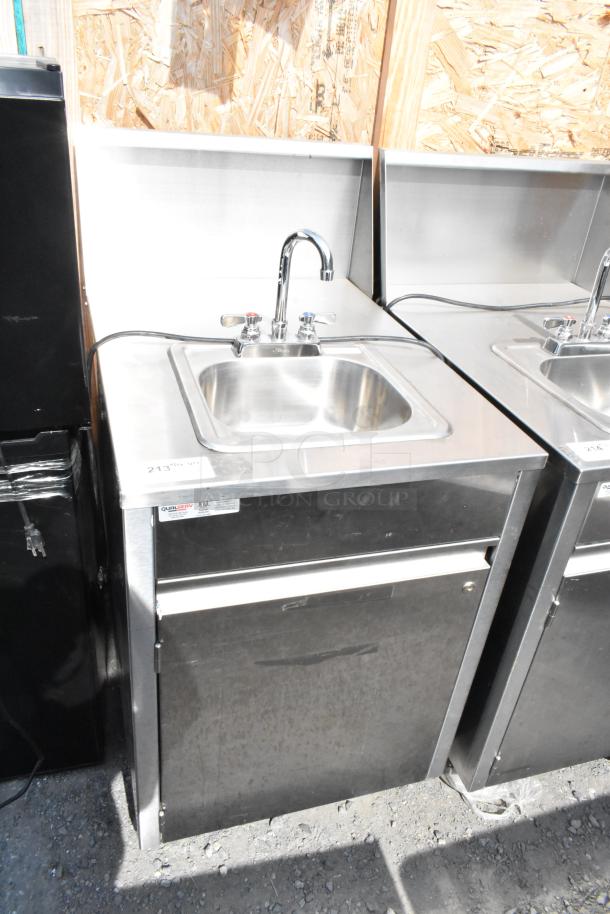 QualServ stainless steel portable sink with faucet, on commercial casters. Includes visible label and power cord. Clean condition.