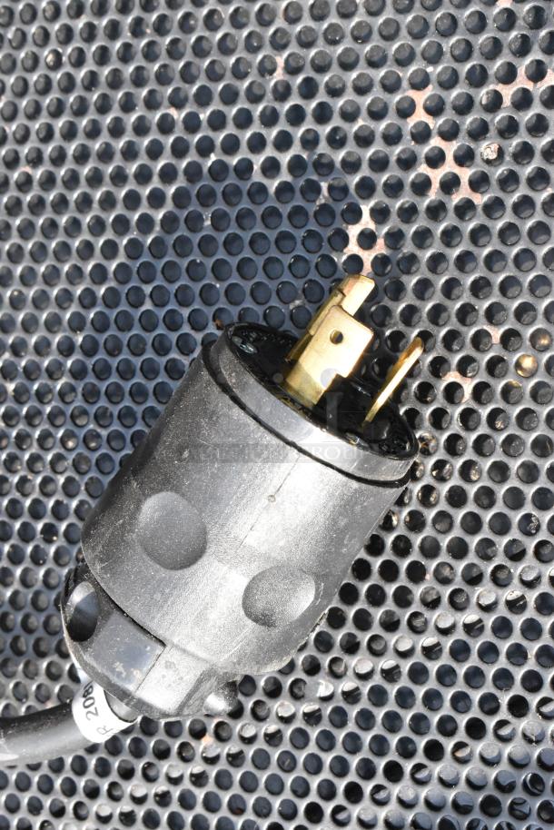 Power plug of Killion Metal Commercial Open Grab N Go Merchandiser, 208/230V, 1 Phase, on perforated surface.
