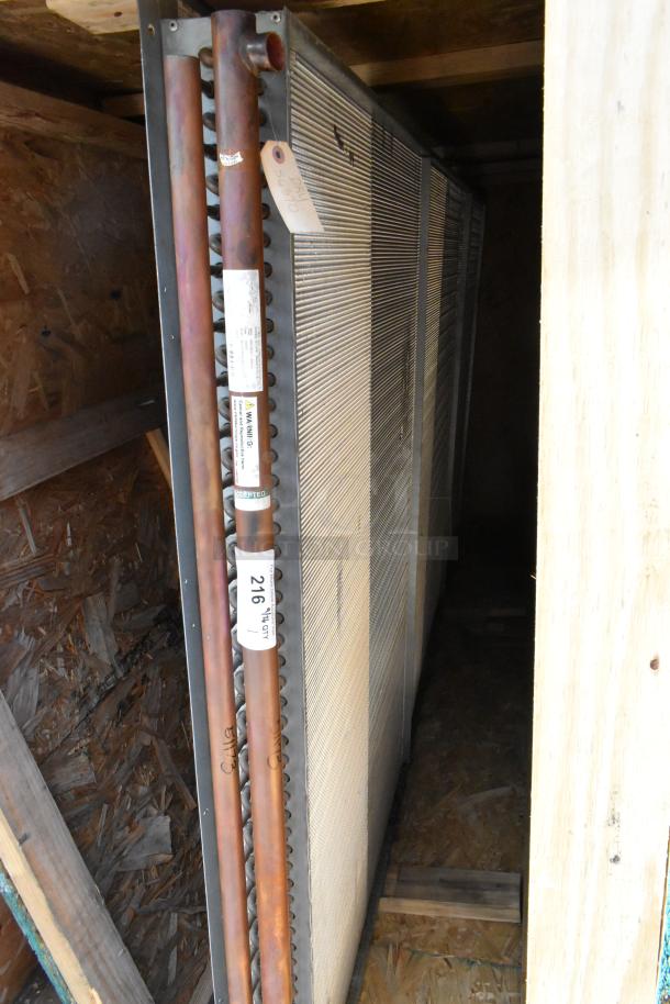 Brand new evaporator coil in crate, featuring copper tubing and fin design. Tags indicate stored "9-2005." Ideal for HVAC systems.
