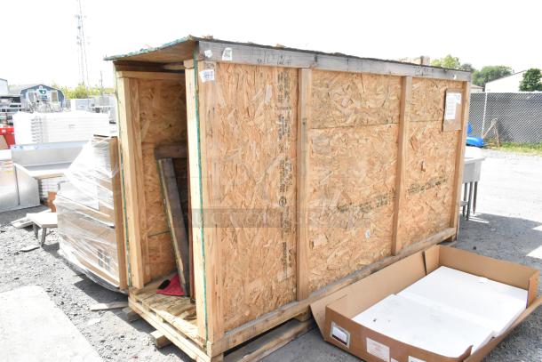 Brand new evaporator coil in a large wooden crate, secure and undamaged, with visible labels indicating specifications.