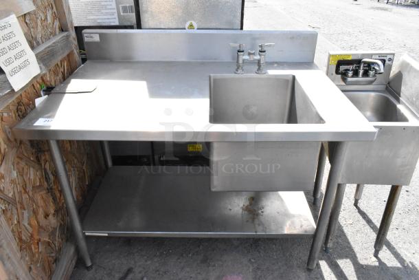 Stainless steel single bay sink with under shelf, faucet included, right side smaller sink, minor wear visible.