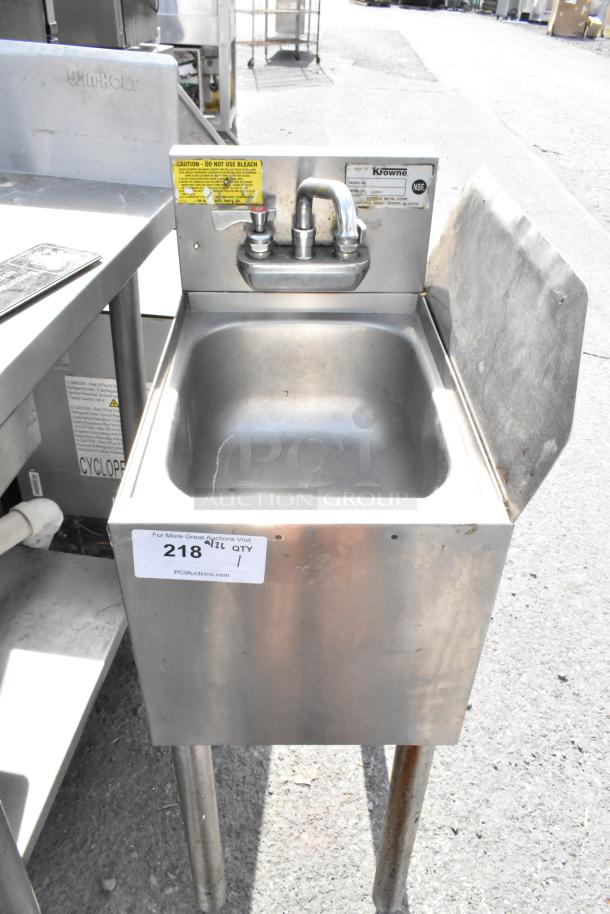 Stainless steel single bay sink with side splash guard, Krowne brand, includes faucet, slight wear visible, auction tag 218.