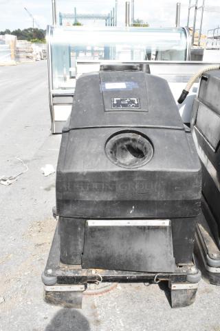 NSS Wrangler 2625 DB Floor Scrubber, used condition, visible wear, black exterior, control panel label on top.