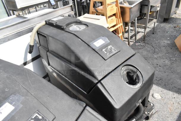 NSS Wrangler 2625 DB floor scrubber in used condition, featuring a sturdy black casing, visible hose, and control panel.