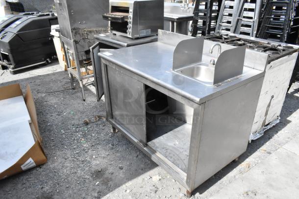 Stainless steel counter with sink basin, sliding doors, and under shelf. Good condition, suitable for commercial kitchens.
