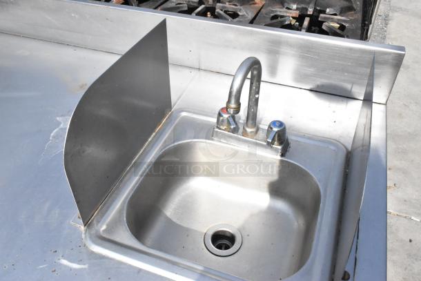 Stainless steel counter with sink basin, dual faucets, side splash guard. Includes doors and under shelf. Pre-owned condition.